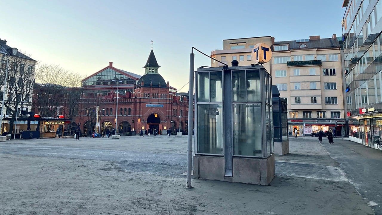 Östermalmstorg en frostig dag. I förgrunden syns tunnelbaneskylten