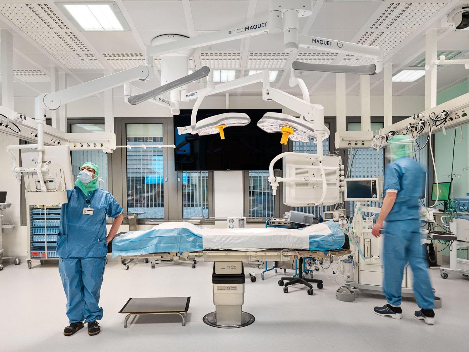 Två medarbetare inom vården förbereder ett operationsrum.