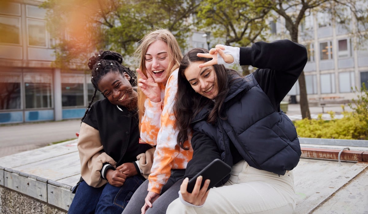 En grupp unga kvinnor sitter på en bänk.