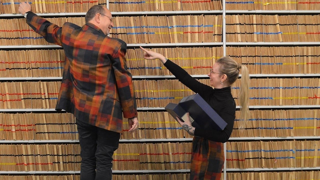 Två personer framför fylla arkivhyllor.