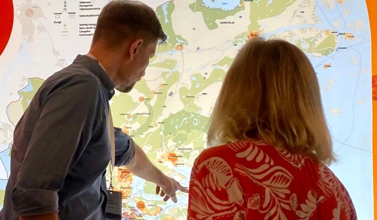 Två personer tittar på en upplyst karta över Stockholmsregionen