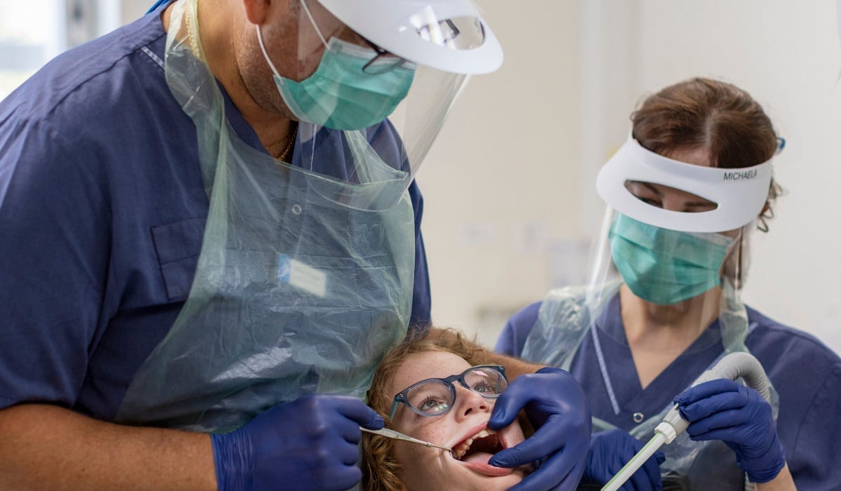 Tandläkare utför en undersökning på ett barn