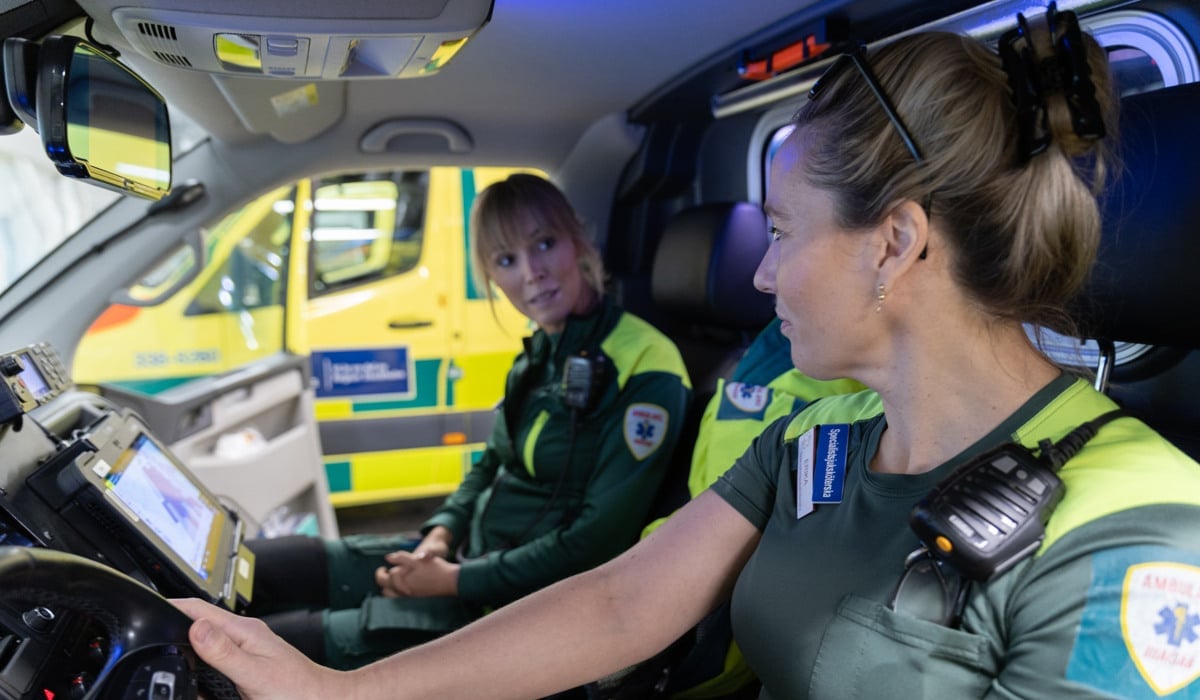 En kvinna som sitter i förarsätet i en polisbil.