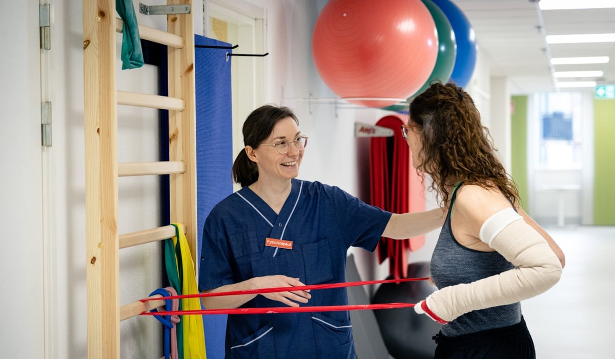 En kvinna med gipsad arm och en annan kvinna som står bredvid.