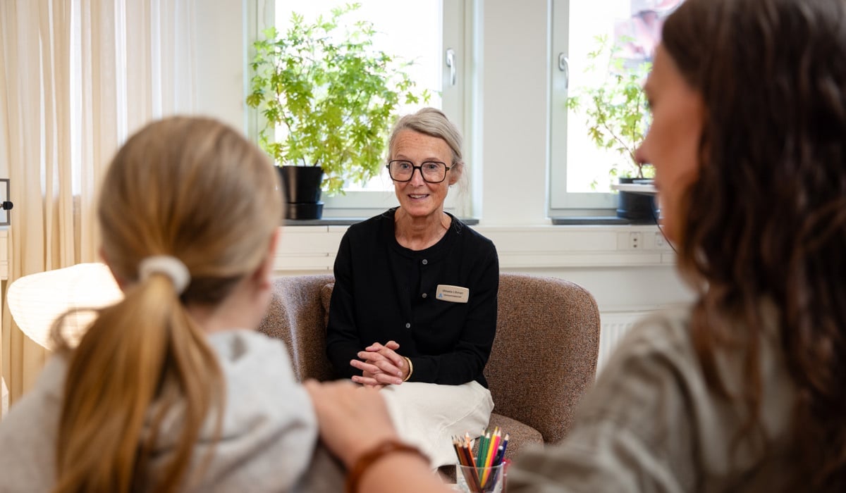 En grupp kvinnor som sitter runt ett bord och pratar.