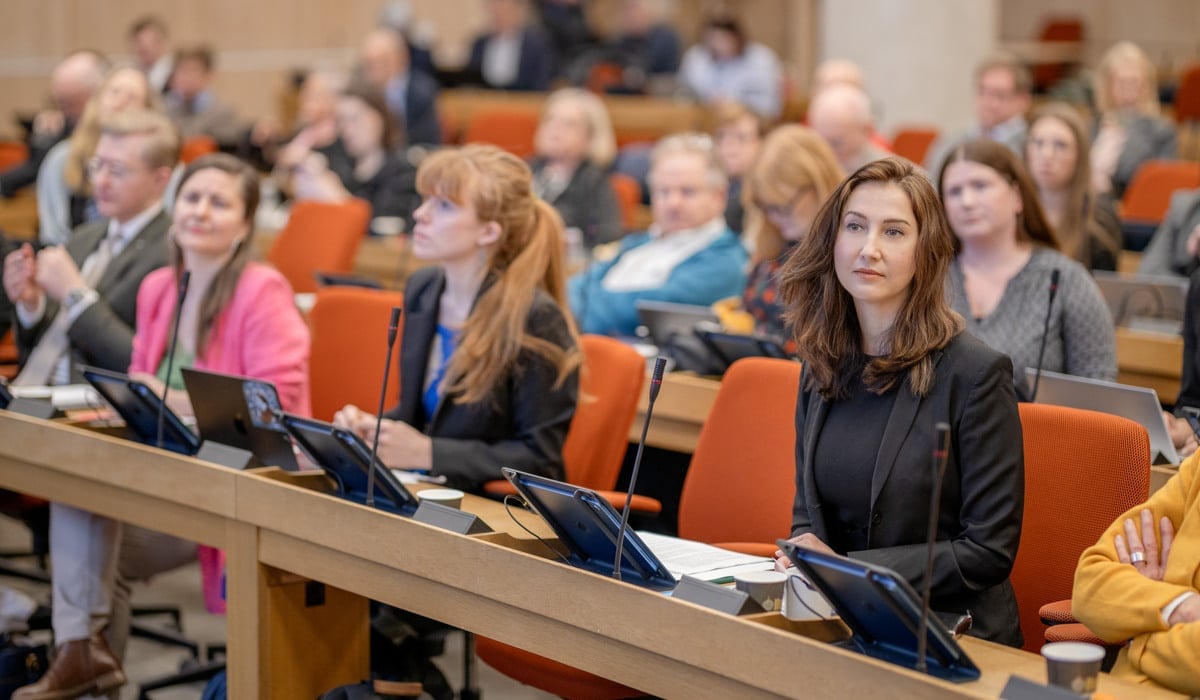 En grupp människor som sitter i ett rum med bärbara datorer