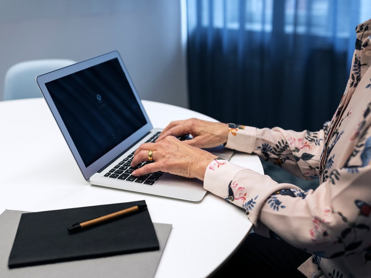 En kvinnas händer på tangentbord till bärbar dator