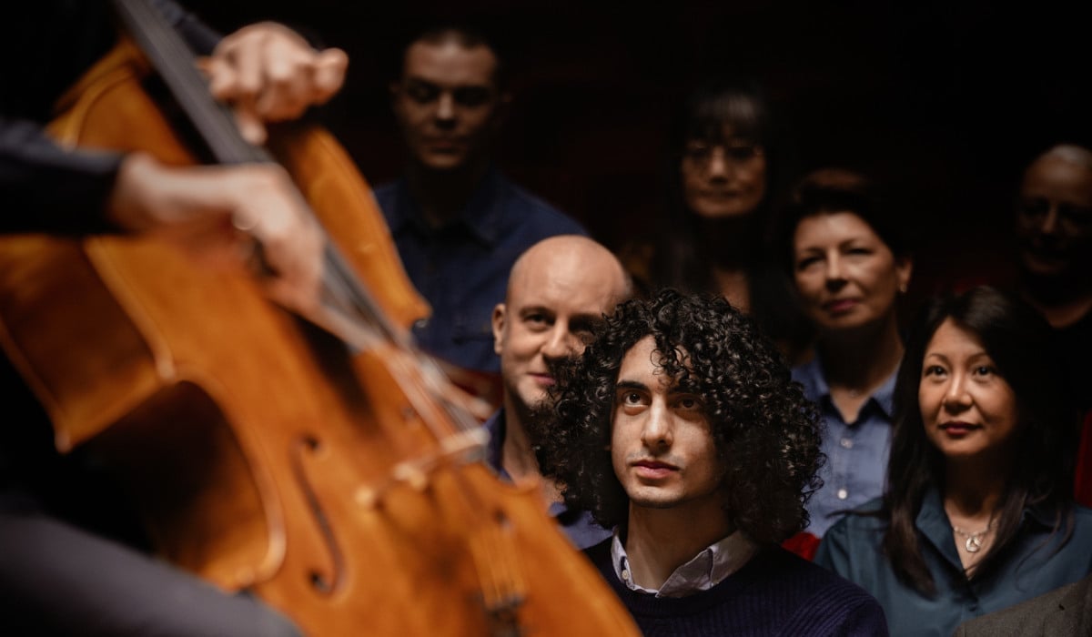 En person spelar cello på en scen och en publik sitter och tittar.