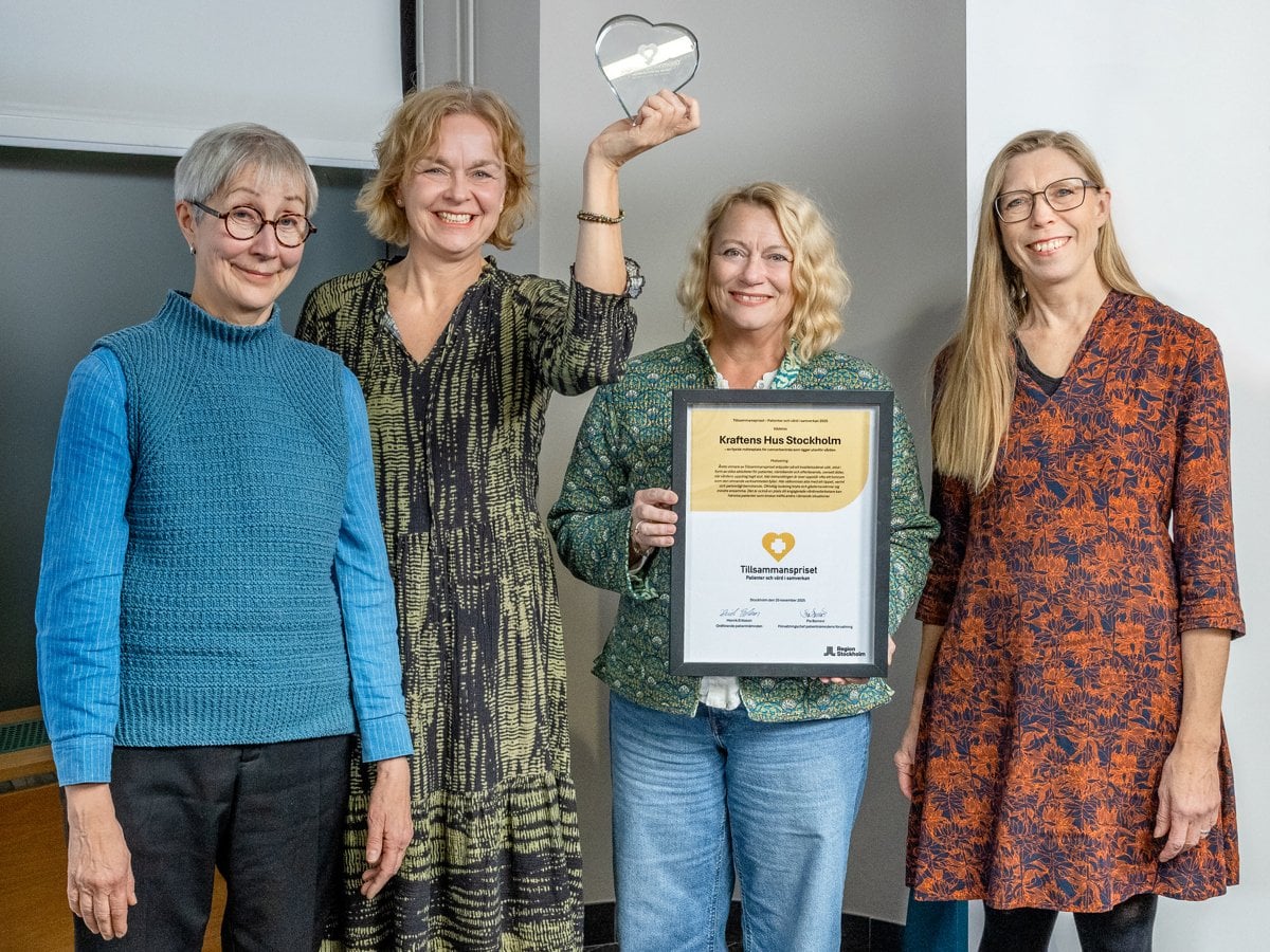 En grupp kvinnor som står bredvid varandra och håller i en plakett.