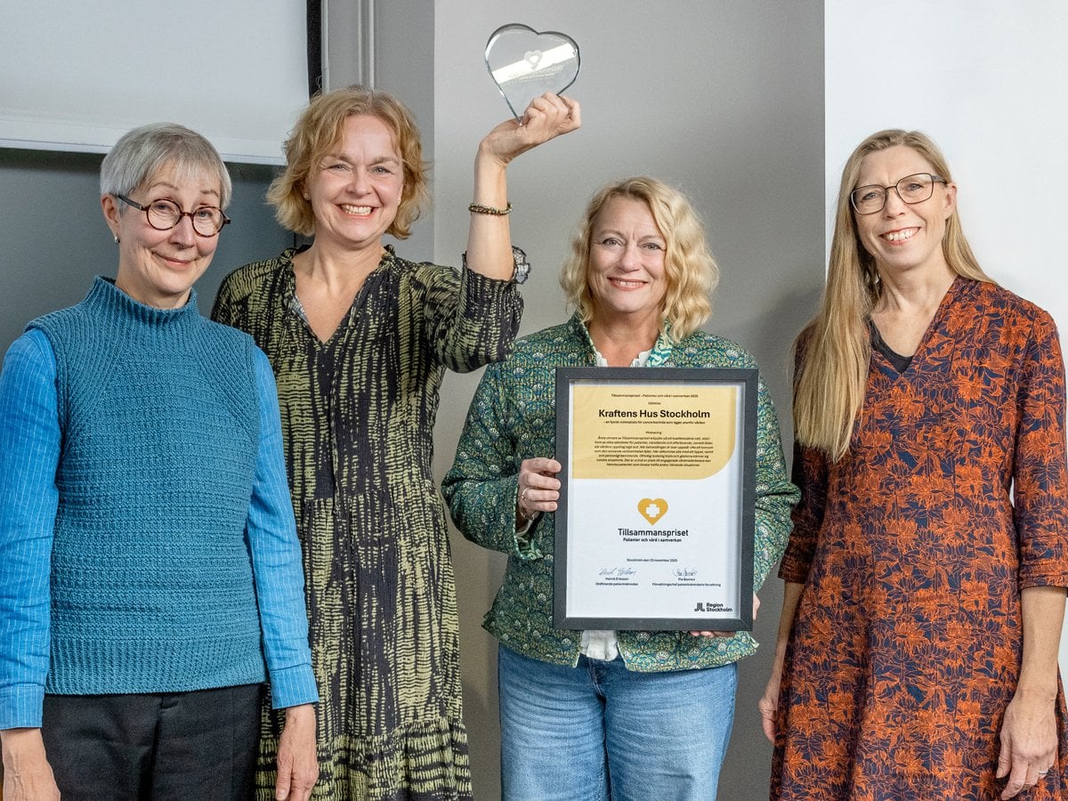 En grupp kvinnor som står bredvid varandra och håller i en plakett.