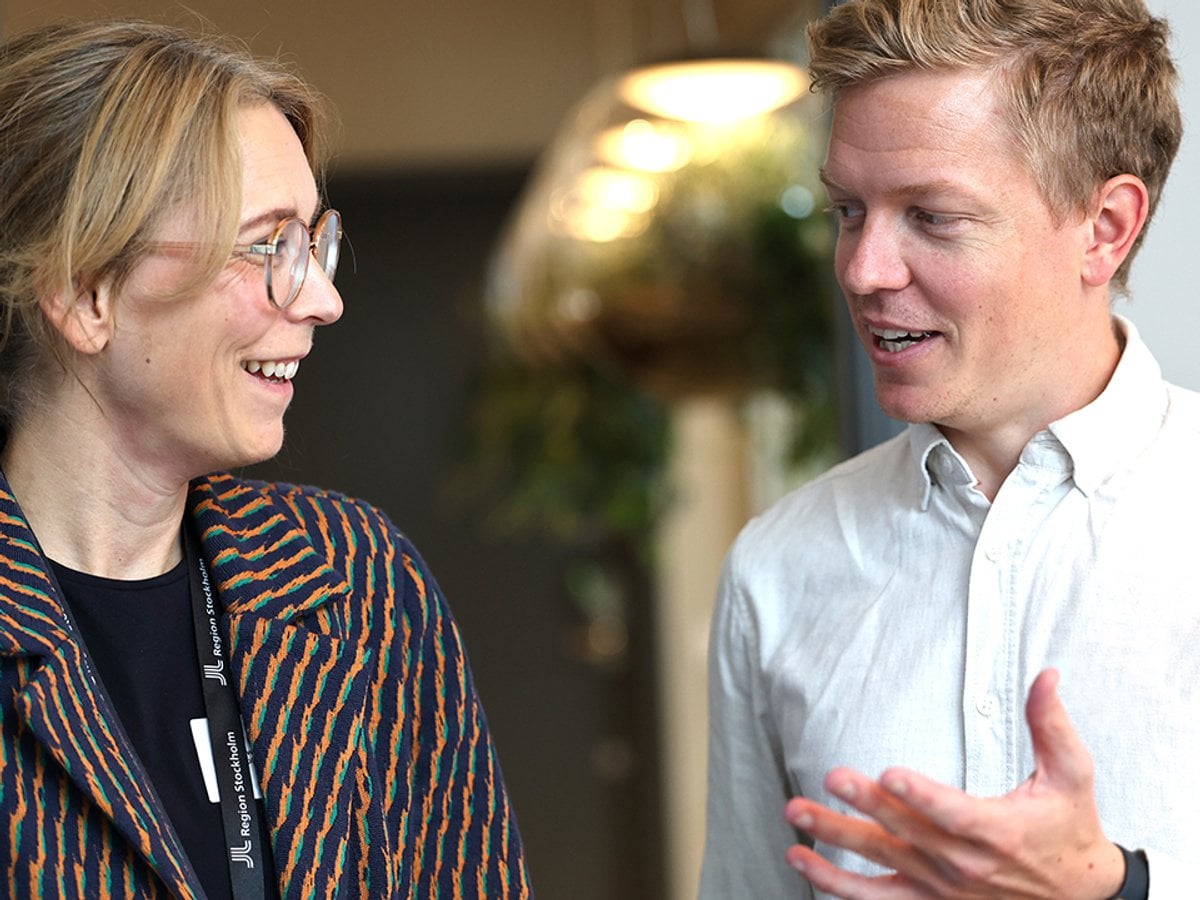 Foto på två personer som pratar med varandra.