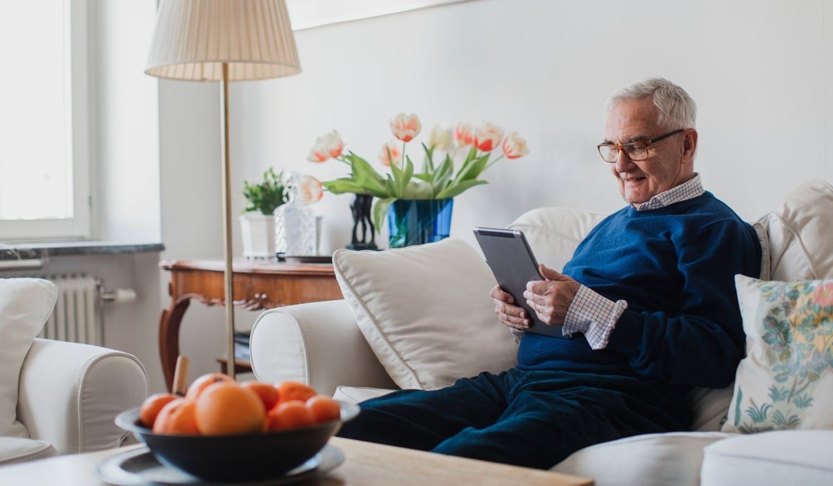 Äldre man med läsplatta