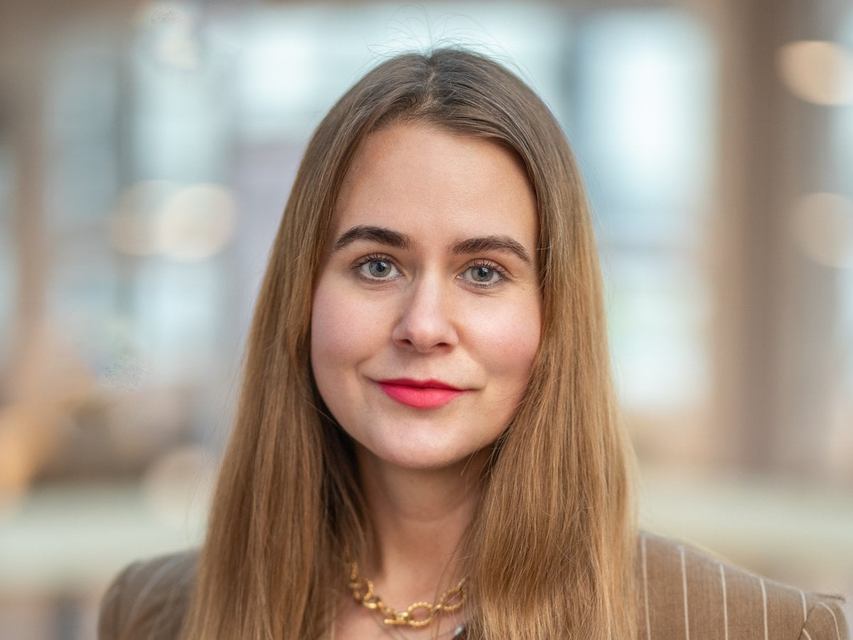 En kvinna med långt hår som bär kostym.