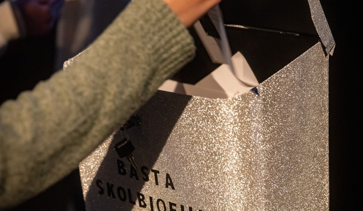 Handen på en elev som lägger en papperslapp i en låda märkt "Bästa skolbiofilm"