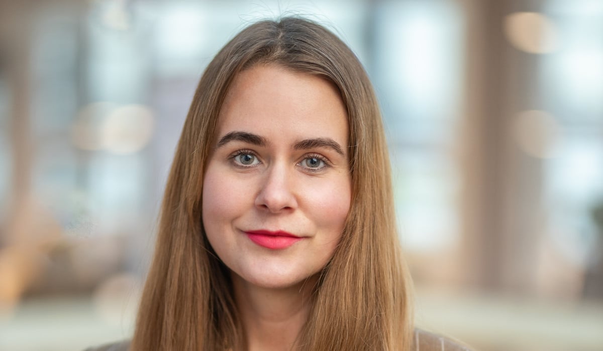 En kvinna med långt hår som bär kostym.