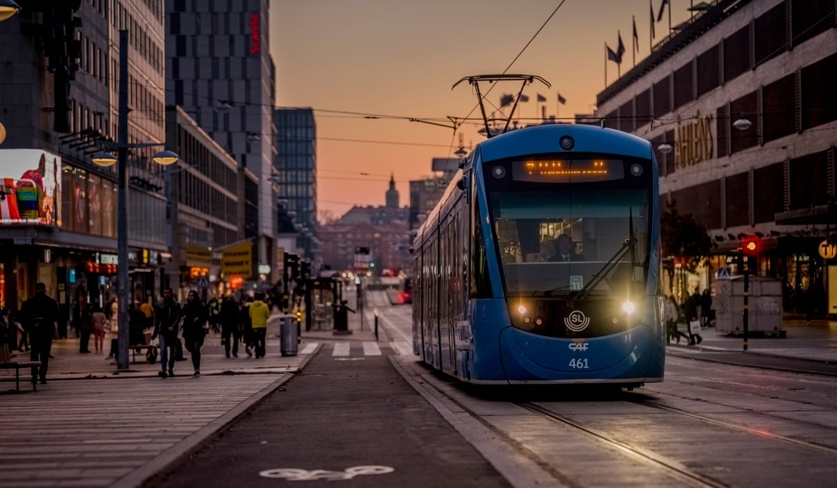 Skymning i centrala Stockholm och spårvagnen står åker förbi Sergels torg.