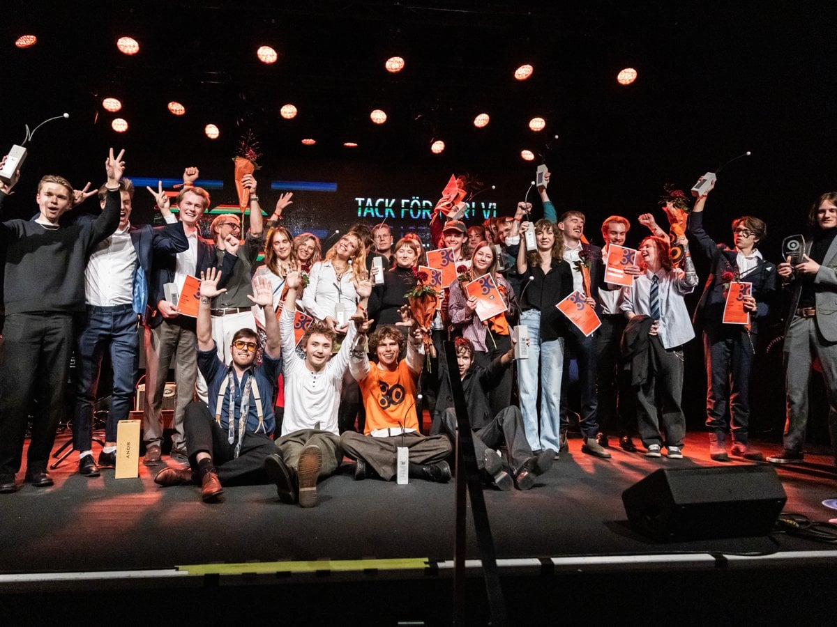 Gruppbild på glada vinnare med priser i händerna.