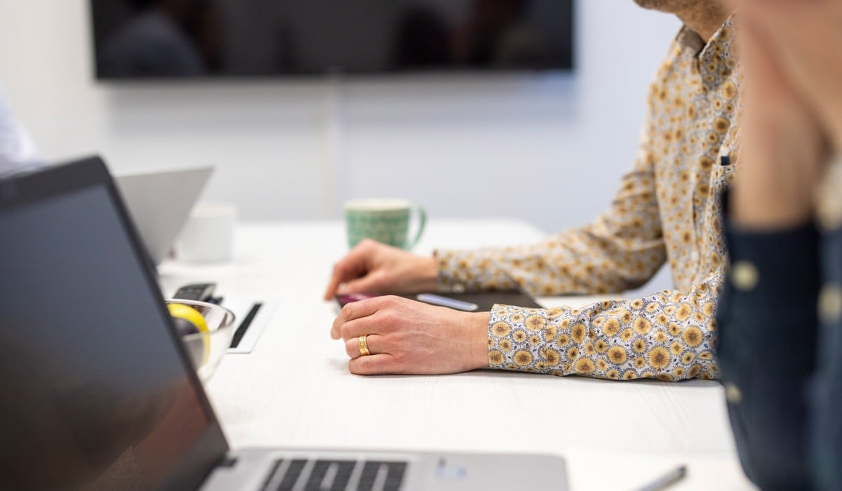 Två personer som sitter vid ett bord och tittar på en dator.