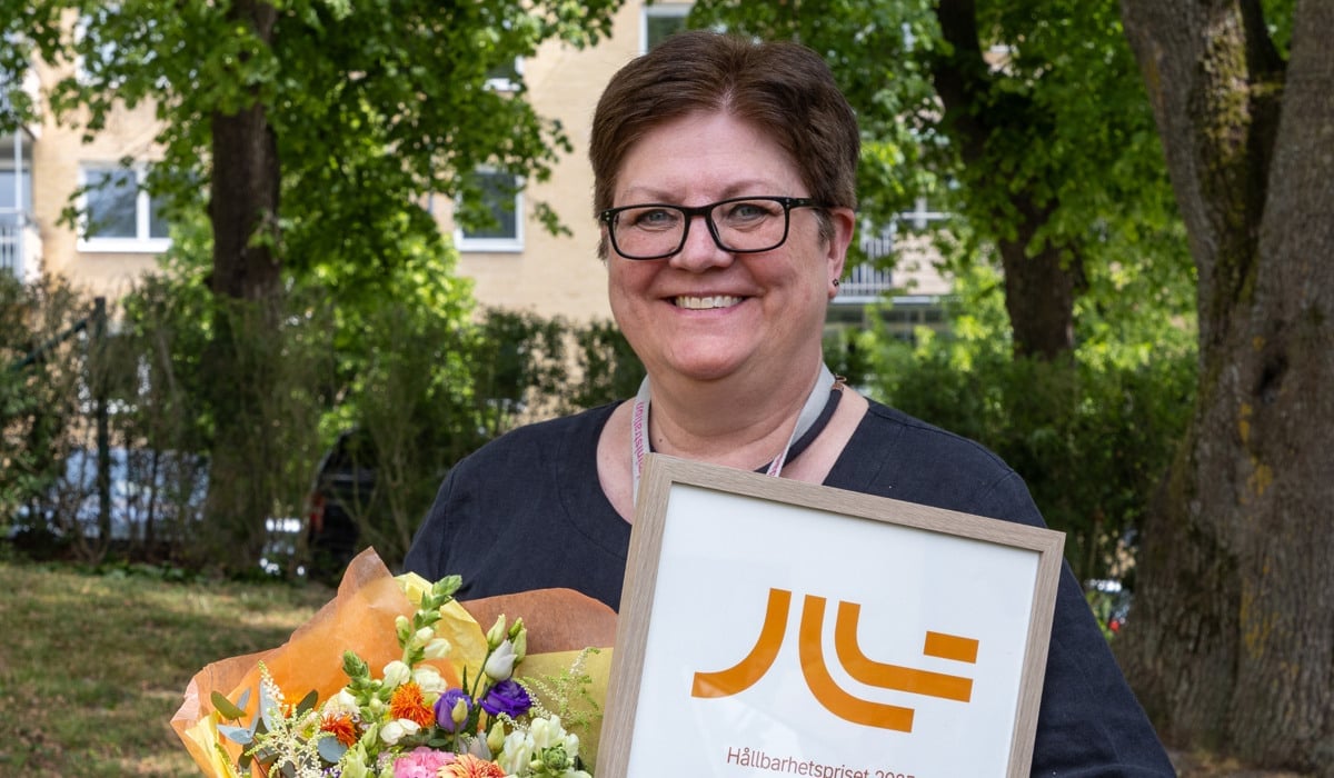 Foto på Susanne Fryklin som håller i blommor och diplom.