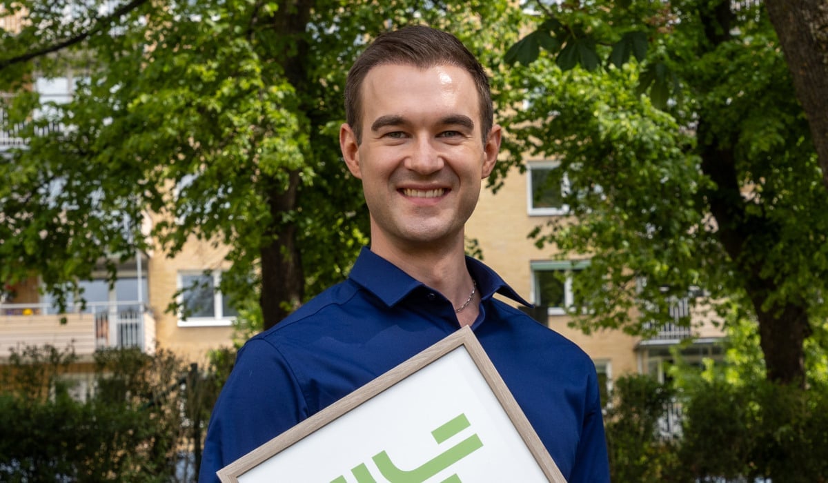 Foto på John Söderberg som håller i diplom och blommor