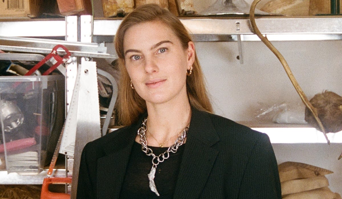 Konstnären Ellen Hedin, framför en hylla med slöjdmaterial.