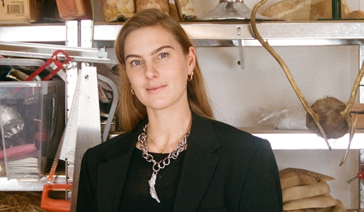 Konstnären Ellen Hedin, framför en hylla med slöjdmaterial.