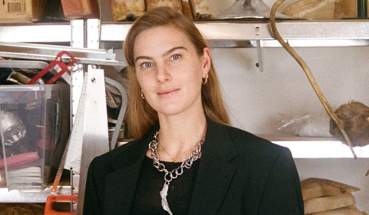 Konstnären Ellen Hedin, framför en hylla med slöjdmaterial.